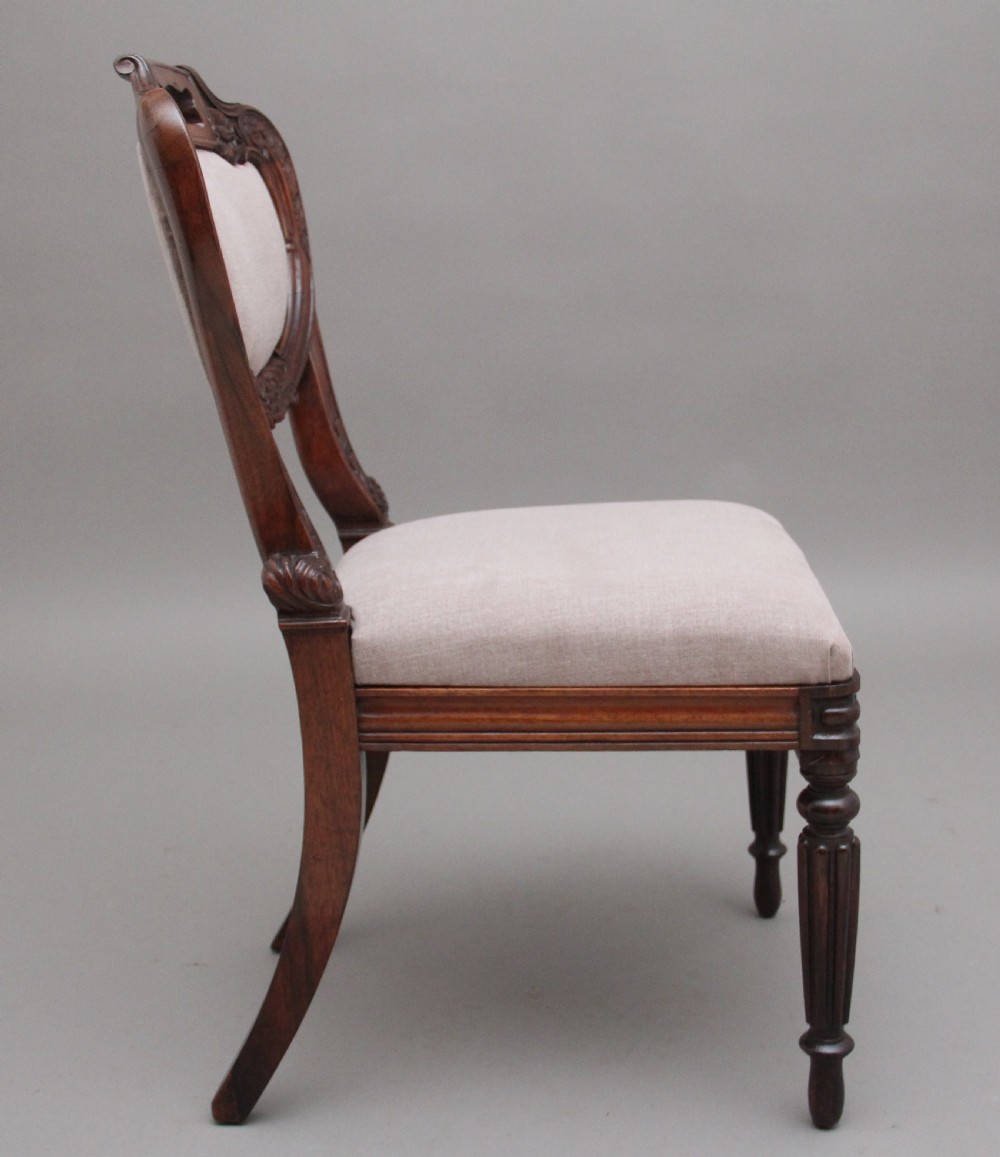 A set of six carved dark rosewood dining chairs with neutral fabric upholstered seats and padded backs. View III