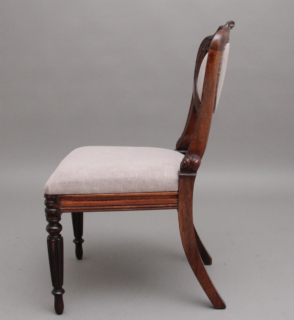 A set of six carved dark rosewood dining chairs with neutral fabric upholstered seats and padded backs. View V