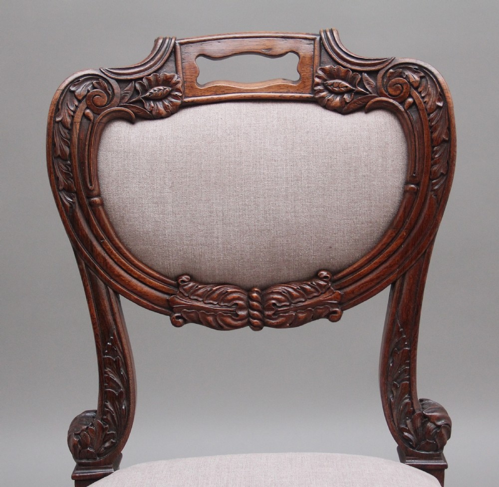 A set of six carved dark rosewood dining chairs with neutral fabric upholstered seats and padded backs. View VI