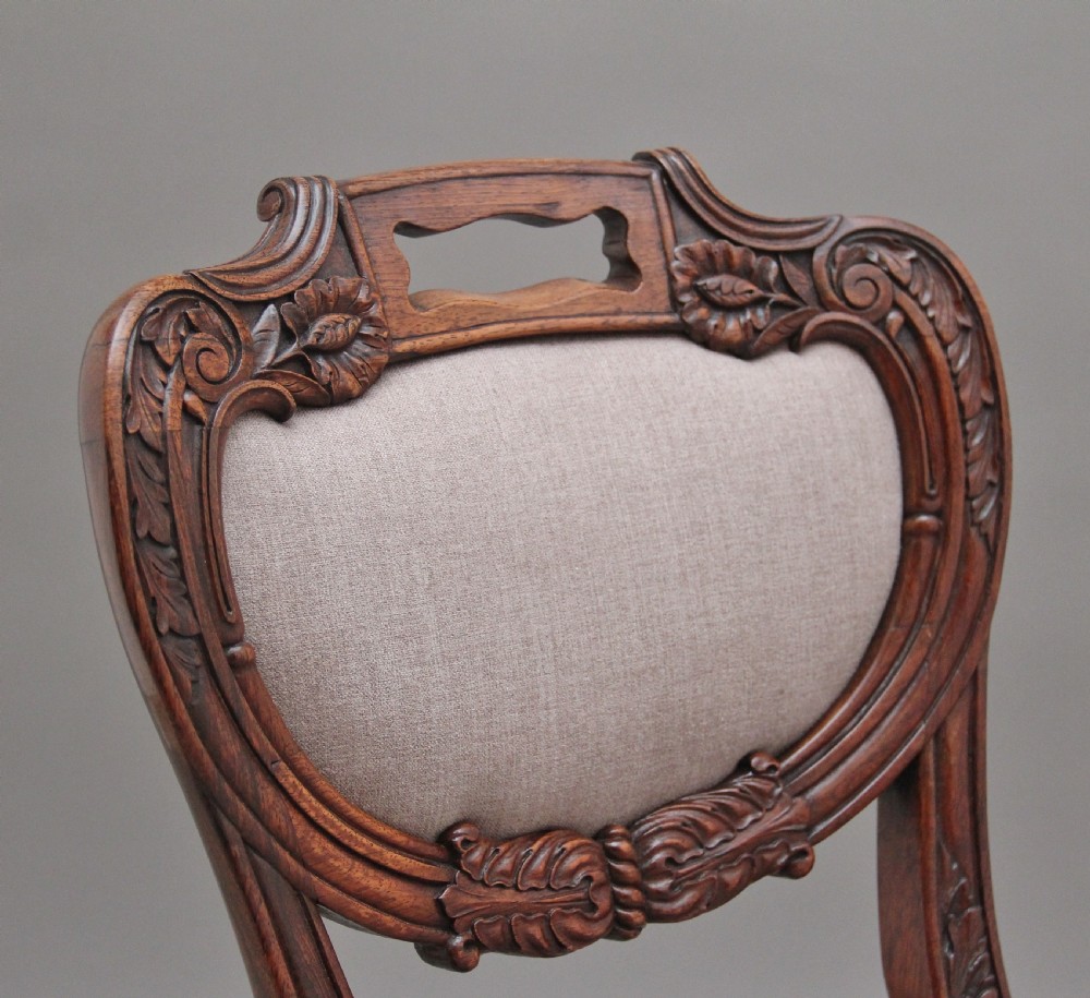 A set of six carved dark rosewood dining chairs with neutral fabric upholstered seats and padded backs. View VIII