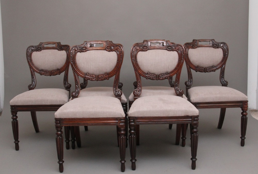 A set of six carved dark rosewood dining chairs with neutral fabric upholstered seats and padded backs. View X