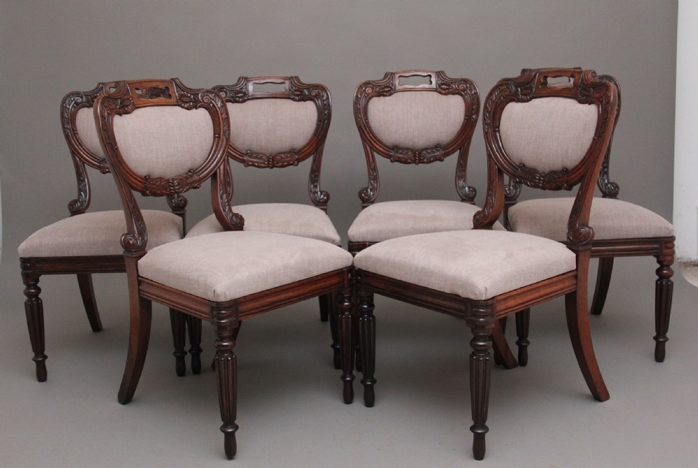 A set of six carved dark rosewood dining chairs with neutral fabric upholstered seats and padded backs. View XI