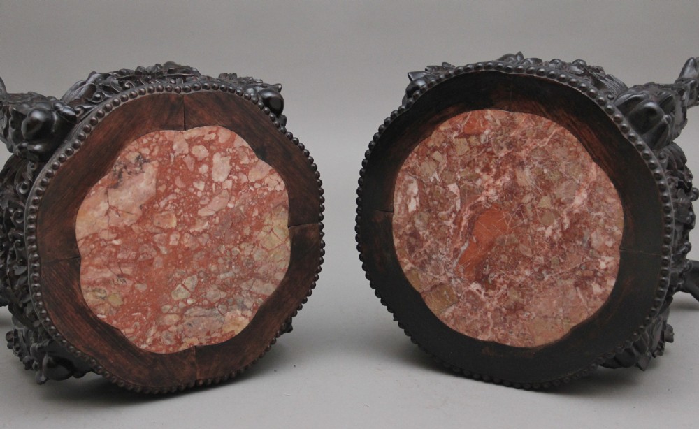 A pair of 19th-century Chinese dark hardwood low stands featuring carved pierced aprons, cabriole legs with claw feet, and round pink marble tops. View VIII