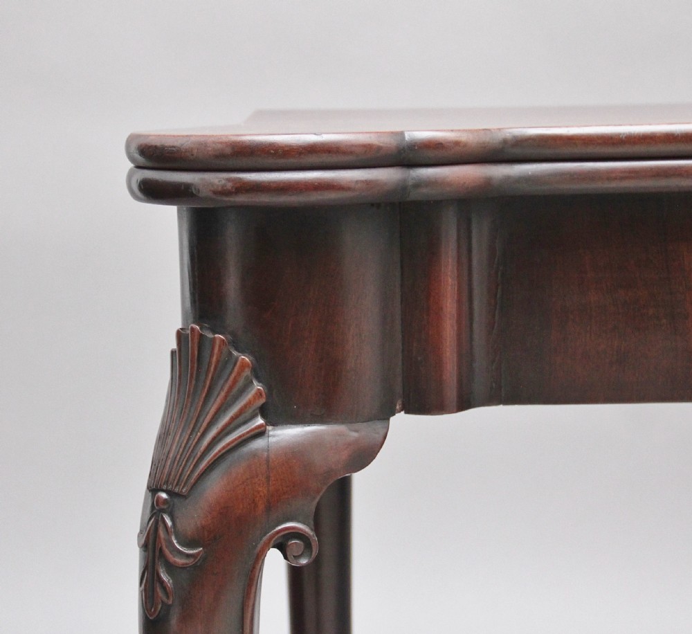 An 18th-century dark mahogany games table with a fold-over top, shell-carved cabriole legs, pad feet, and a central drawer. View III