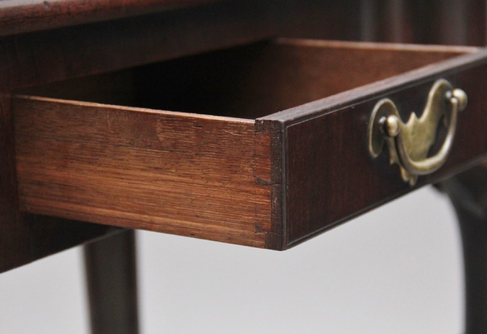 An 18th-century dark mahogany games table with a fold-over top, shell-carved cabriole legs, pad feet, and a central drawer. View VI