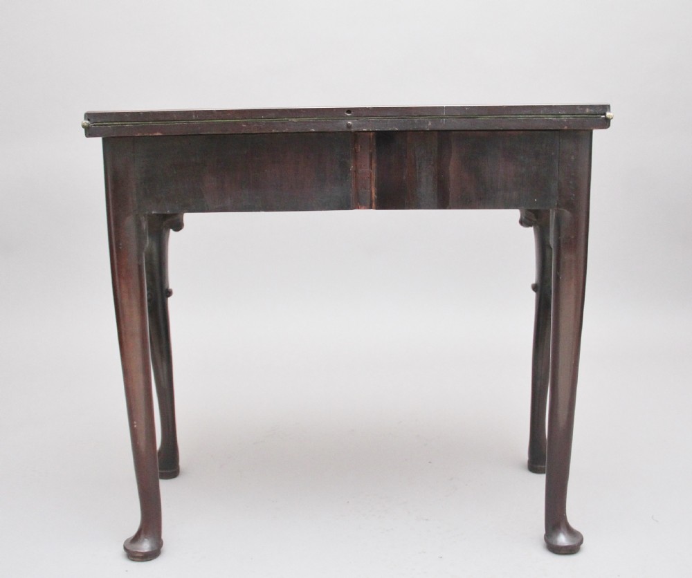 An 18th-century dark mahogany games table with a fold-over top, shell-carved cabriole legs, pad feet, and a central drawer. View VIII