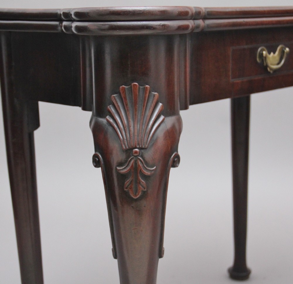 An 18th-century dark mahogany games table with a fold-over top, shell-carved cabriole legs, pad feet, and a central drawer. View XI