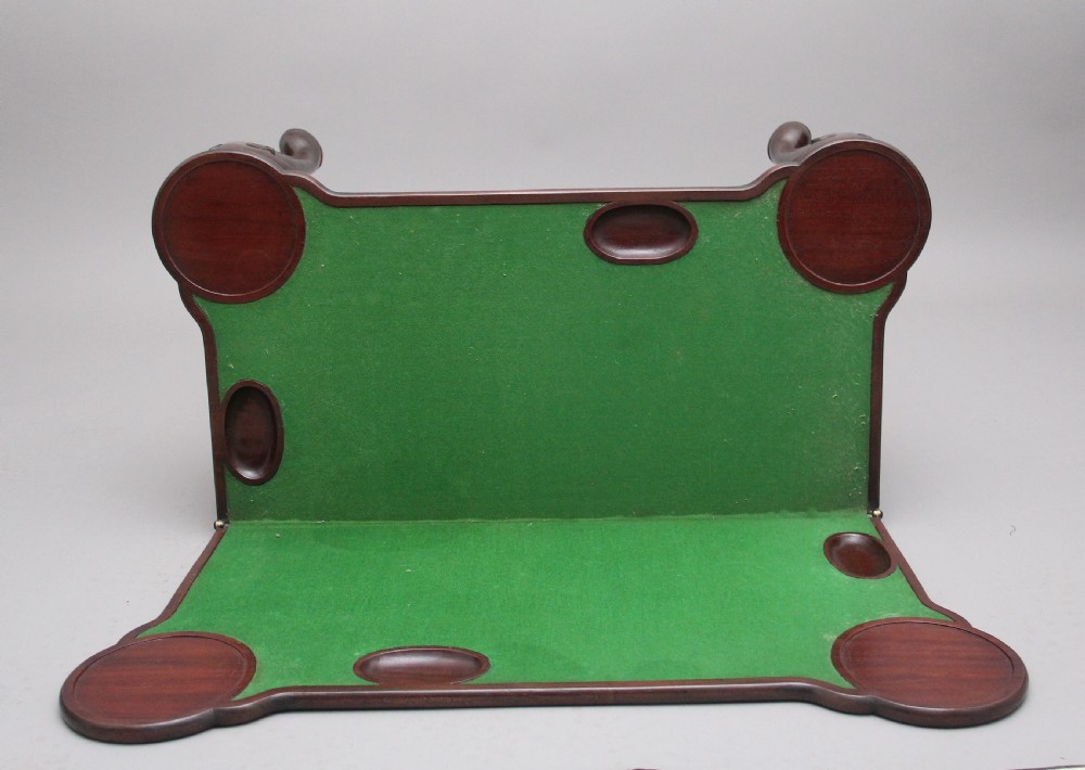 An 18th-century dark mahogany games table with a fold-over top, shell-carved cabriole legs, pad feet, and a central drawer. View XIII
