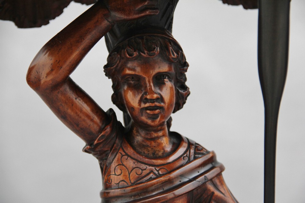 A dark carved wood Venetian figure stand featuring a gondolier holding an oar on a gondola hull, supporting a fringed draped tray surface. View IX
