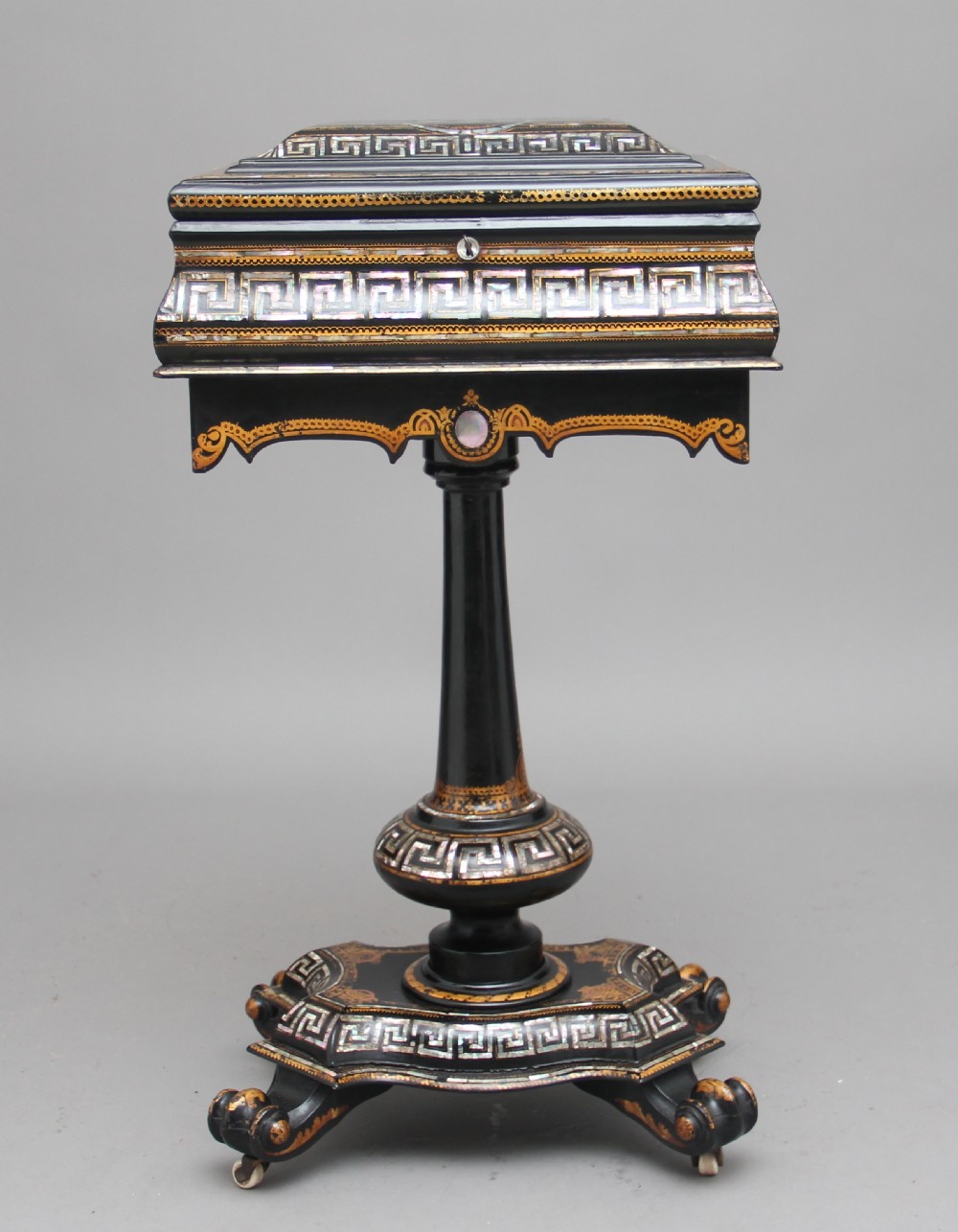 A nineteenth-century black lacquered papier-mache work table featuring mother-of-pearl Greek key inlay, hand-gilded detailing, a hinged box top, and a pedestal base on castors. View VII