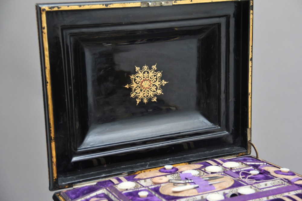 A nineteenth-century black lacquered papier-mache work table featuring mother-of-pearl Greek key inlay, hand-gilded detailing, a hinged box top, and a pedestal base on castors. View XIII