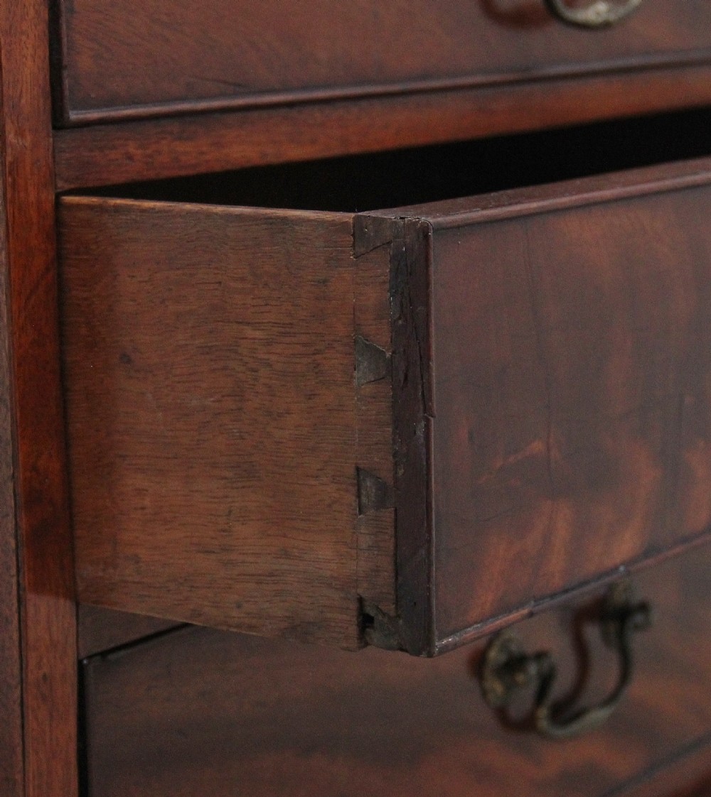 A nineteenth-century mahogany chest of drawers with four brass-handled drawers resting on bracket feet. View V
