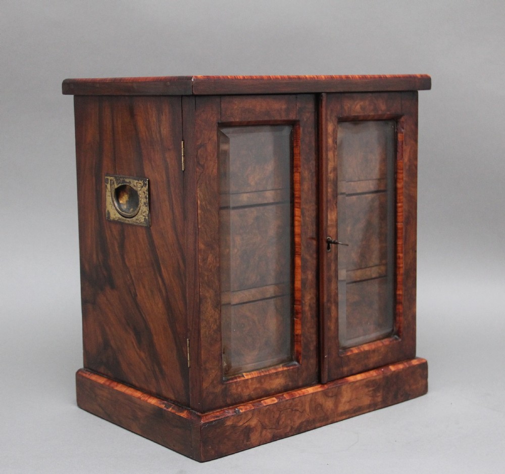 A 19th-century burr walnut tabletop cabinet with an open glazed door showing interior drawers with brass flush handles. View II