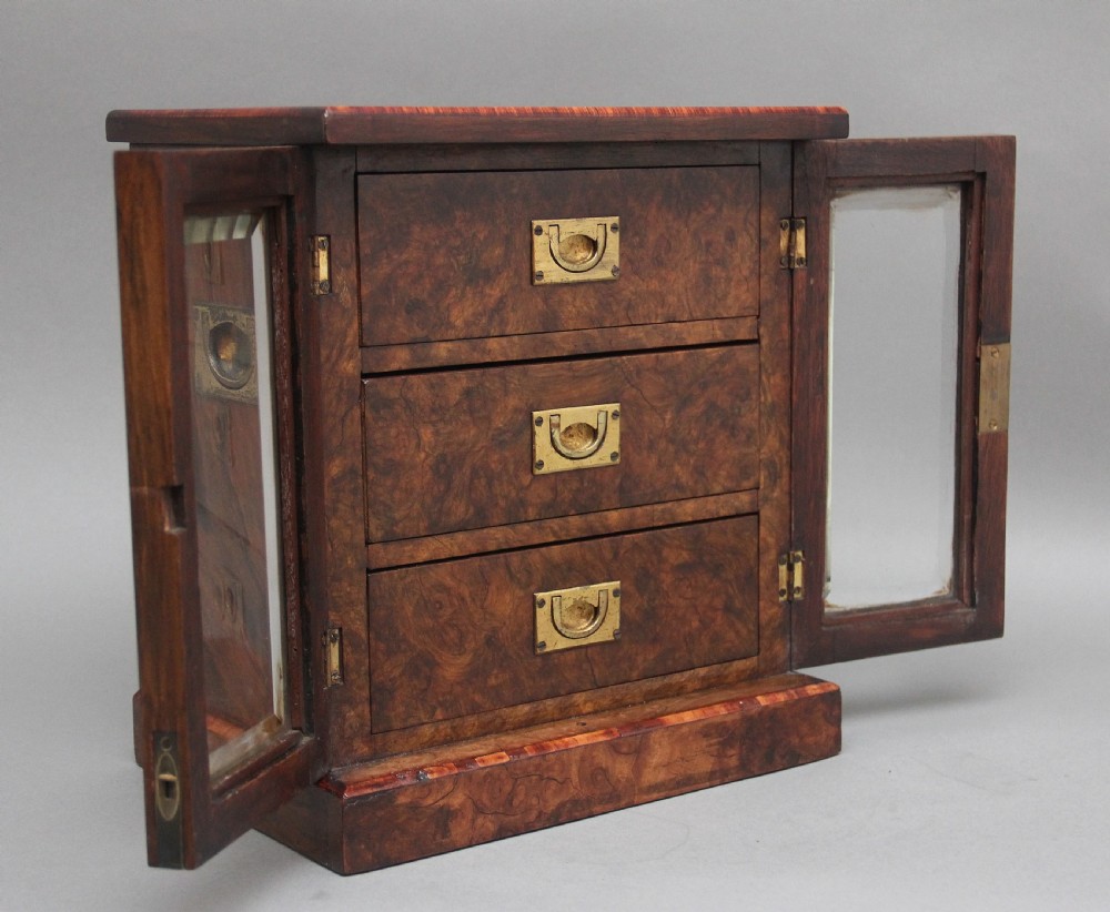 A 19th-century burr walnut tabletop cabinet with an open glazed door showing interior drawers with brass flush handles. View III
