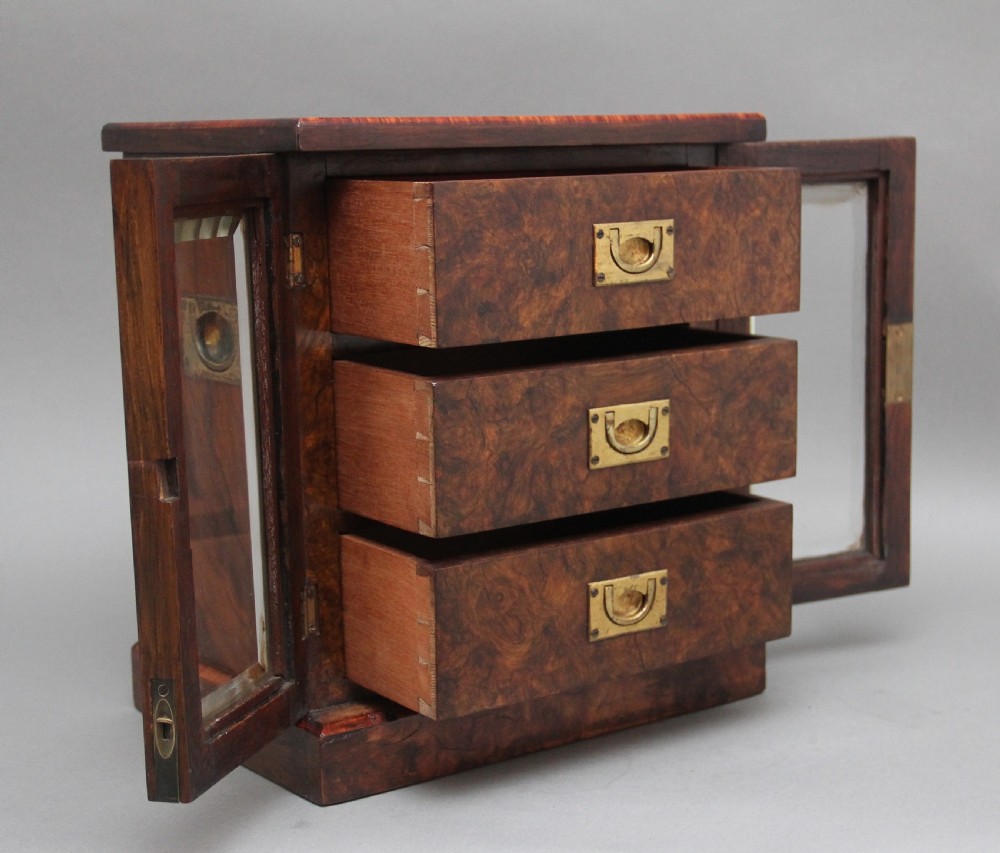A 19th-century burr walnut tabletop cabinet with an open glazed door showing interior drawers with brass flush handles. View IV
