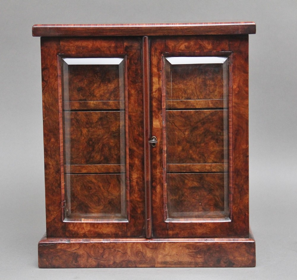 A 19th-century burr walnut tabletop cabinet with an open glazed door showing interior drawers with brass flush handles. View VI
