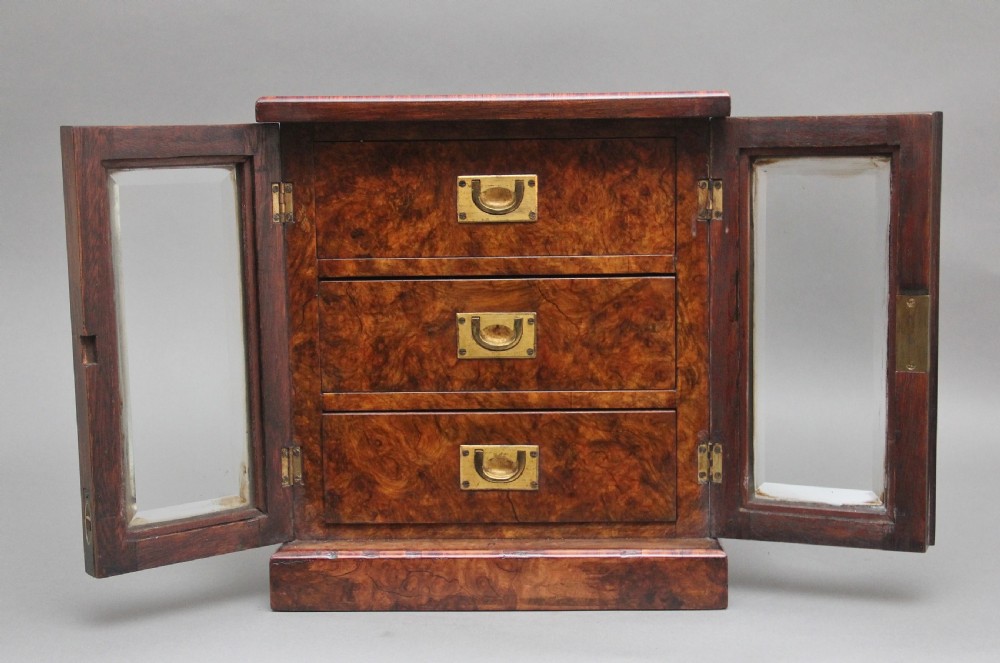 A 19th-century burr walnut tabletop cabinet with an open glazed door showing interior drawers with brass flush handles. View VII