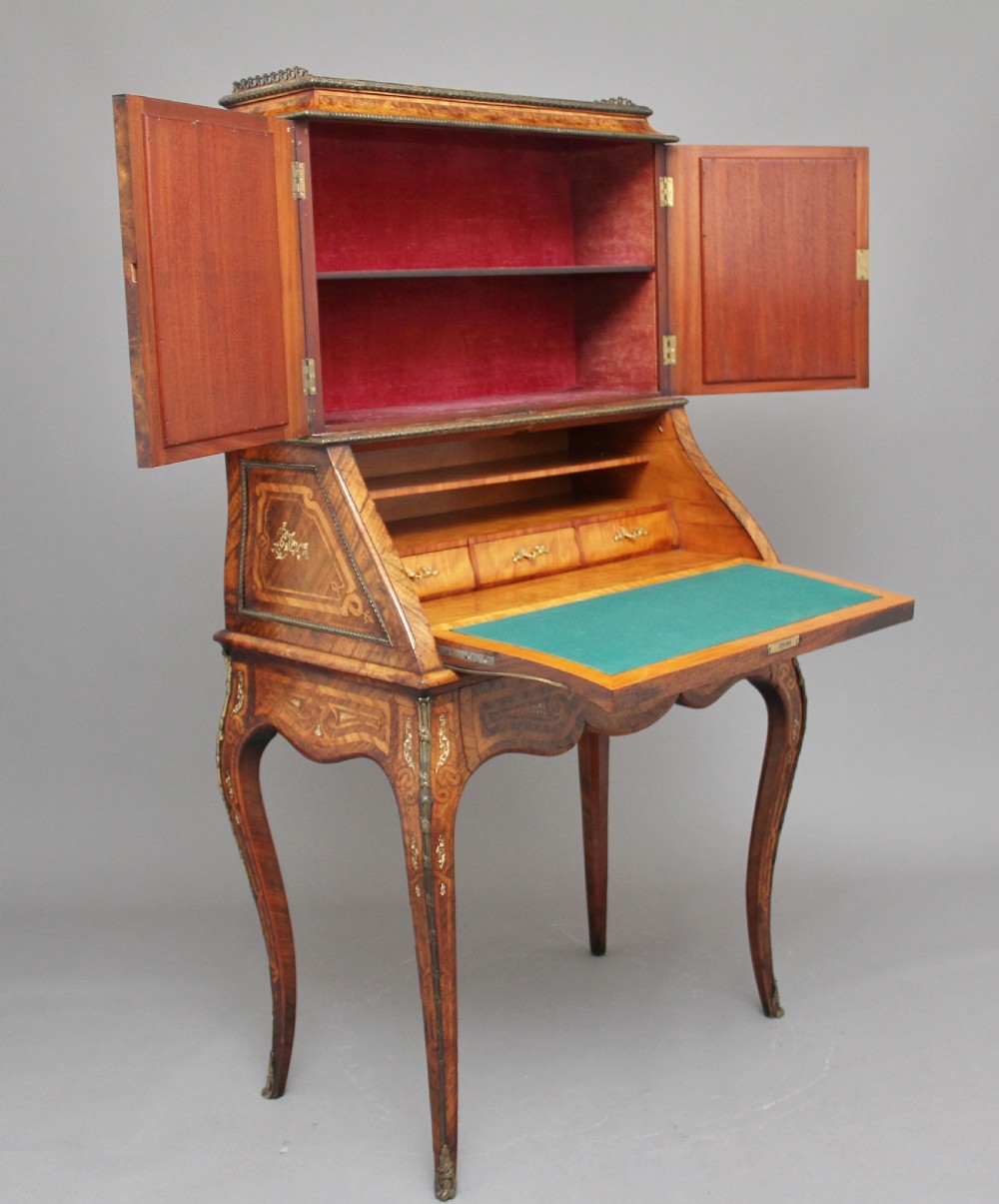 A nineteenth-century French walnut and kingwood bureau de dame with floral marquetry inlay, brass mounts, cabriole legs, and an upper cabinet with mirrored doors. View II