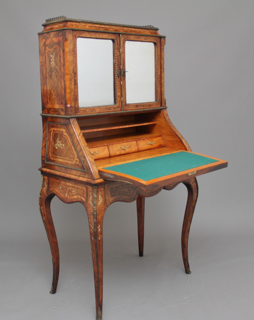 A nineteenth-century French walnut and kingwood bureau de dame with floral marquetry inlay, brass mounts, cabriole legs, and an upper cabinet with mirrored doors. View III