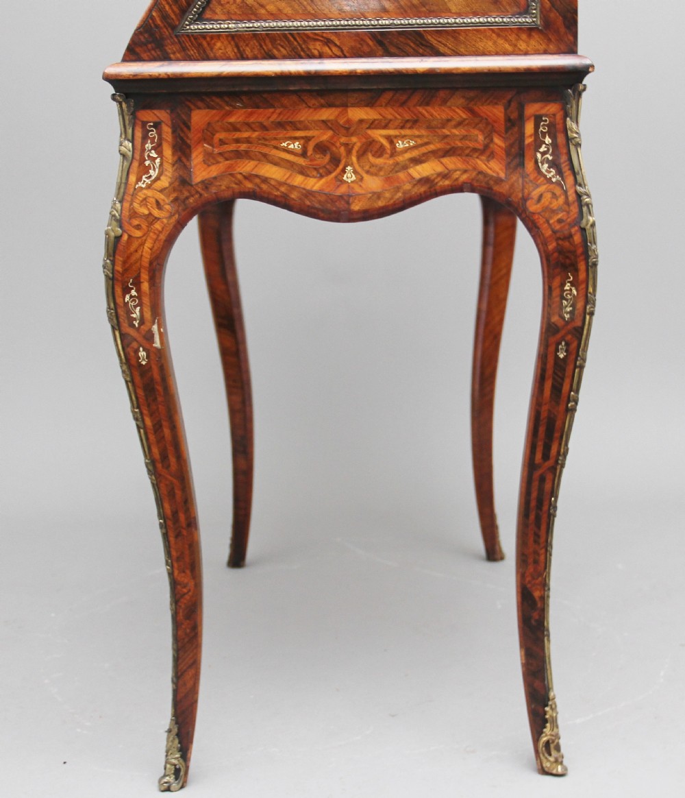A nineteenth-century French walnut and kingwood bureau de dame with floral marquetry inlay, brass mounts, cabriole legs, and an upper cabinet with mirrored doors. View IX