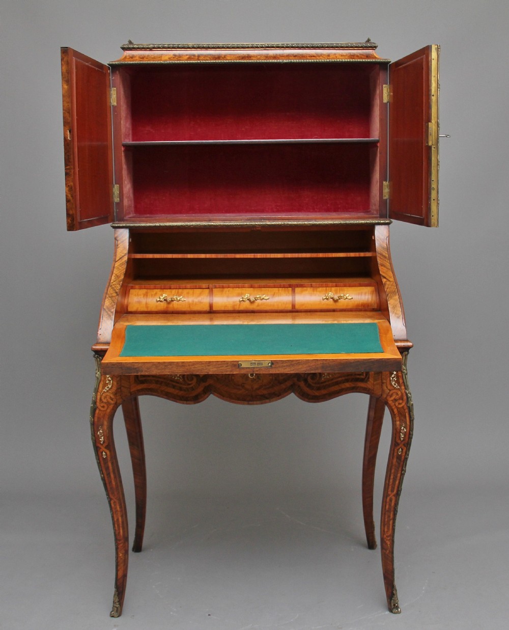 A nineteenth-century French walnut and kingwood bureau de dame with floral marquetry inlay, brass mounts, cabriole legs, and an upper cabinet with mirrored doors. View XII