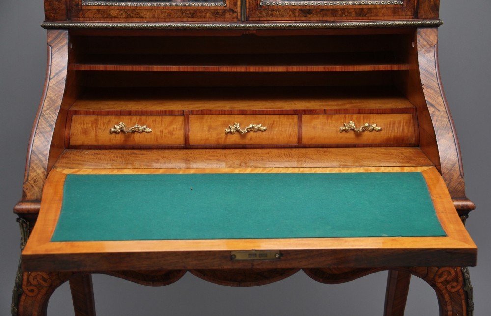 A nineteenth-century French walnut and kingwood bureau de dame with floral marquetry inlay, brass mounts, cabriole legs, and an upper cabinet with mirrored doors. View XIII