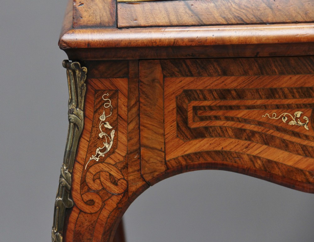 A nineteenth-century French walnut and kingwood bureau de dame with floral marquetry inlay, brass mounts, cabriole legs, and an upper cabinet with mirrored doors. View XX