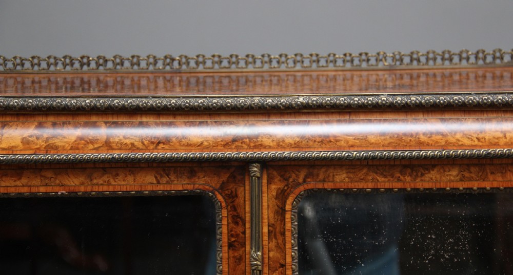 A nineteenth-century French walnut and kingwood bureau de dame with floral marquetry inlay, brass mounts, cabriole legs, and an upper cabinet with mirrored doors. View XXIV