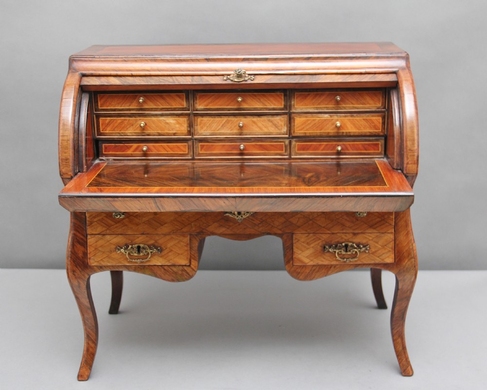 A 19th-century miniature walnut desk with geometric parquetry pattern, a cylinder roll top, cabriole legs, and brass handles. View II