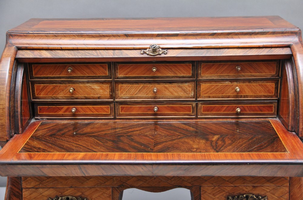 A 19th-century miniature walnut desk with geometric parquetry pattern, a cylinder roll top, cabriole legs, and brass handles. View IV