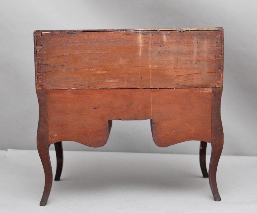 A 19th-century miniature walnut desk with geometric parquetry pattern, a cylinder roll top, cabriole legs, and brass handles. View VI