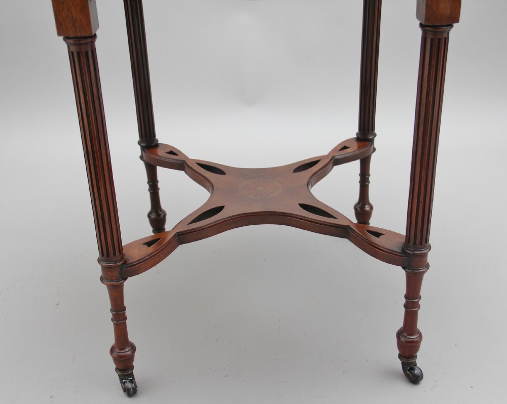 A 19th-century rosewood centre table with a serpentine-edged marquetry top, four fluted legs, an X-shaped stretcher, and brass castors. View VI