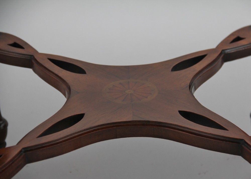 A 19th-century rosewood centre table with a serpentine-edged marquetry top, four fluted legs, an X-shaped stretcher, and brass castors. View VII