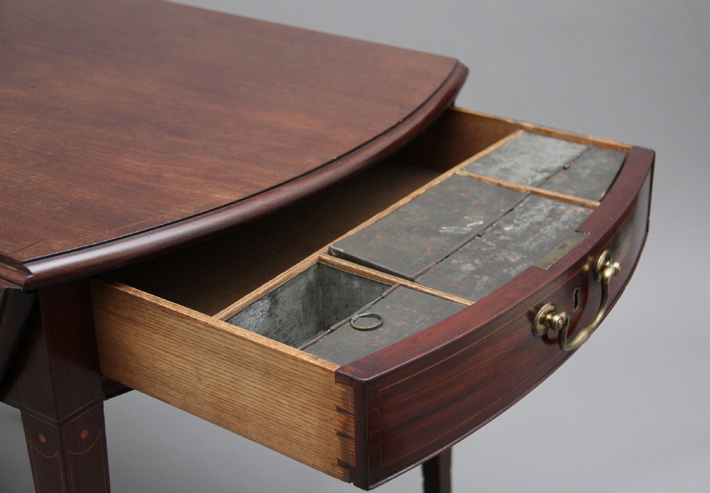 An 18th-century mahogany Pembroke table with two drop leaves, a single frieze drawer with a brass handle, boxwood stringing inlay, and square tapered legs on brass castors. View IV