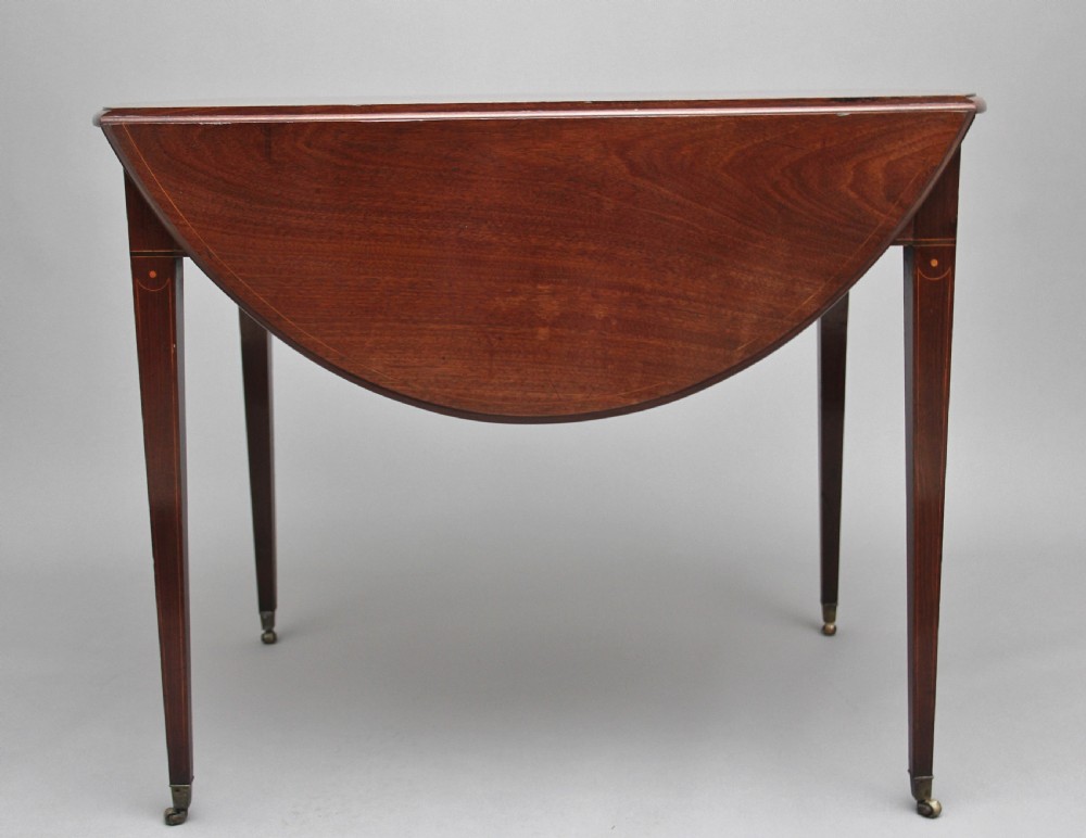An 18th-century mahogany Pembroke table with two drop leaves, a single frieze drawer with a brass handle, boxwood stringing inlay, and square tapered legs on brass castors. View VI