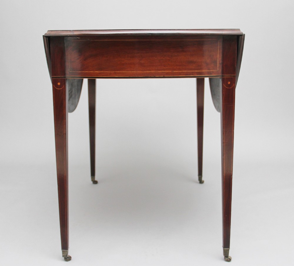 An 18th-century mahogany Pembroke table with two drop leaves, a single frieze drawer with a brass handle, boxwood stringing inlay, and square tapered legs on brass castors. View VII