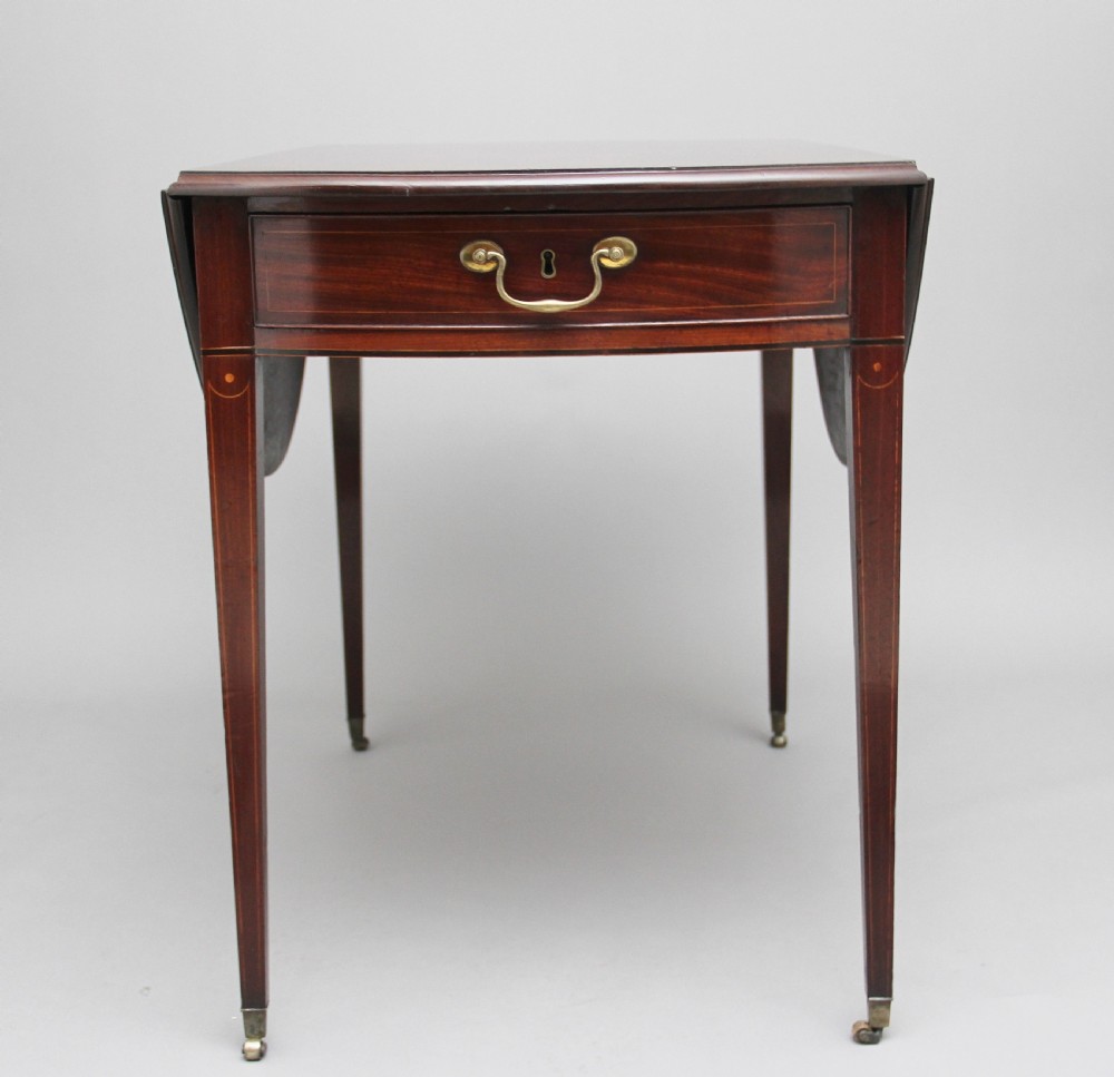 An 18th-century mahogany Pembroke table with two drop leaves, a single frieze drawer with a brass handle, boxwood stringing inlay, and square tapered legs on brass castors. View IX