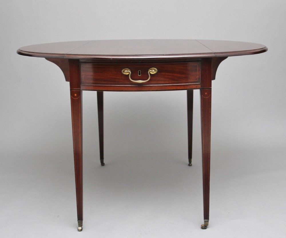 An 18th-century mahogany Pembroke table with two drop leaves, a single frieze drawer with a brass handle, boxwood stringing inlay, and square tapered legs on brass castors. View X