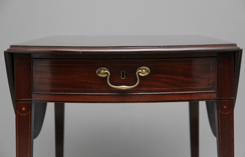 An 18th-century mahogany Pembroke table with two drop leaves, a single frieze drawer with a brass handle, boxwood stringing inlay, and square tapered legs on brass castors. View XIII