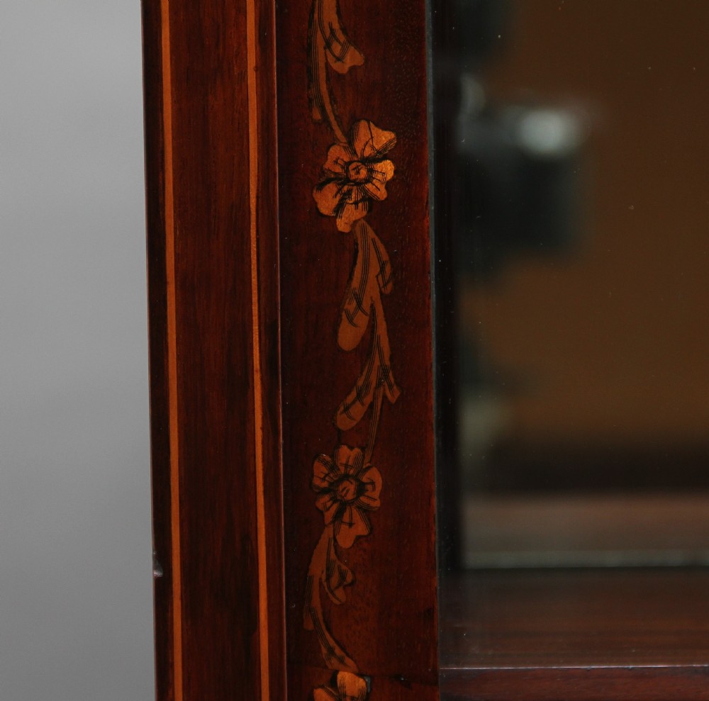 A 19th-century mahogany display cabinet featuring floral marquetry inlays, a glazed upper section with glass shelves, and a bow-front lower cabinet on tapered legs. View XIII