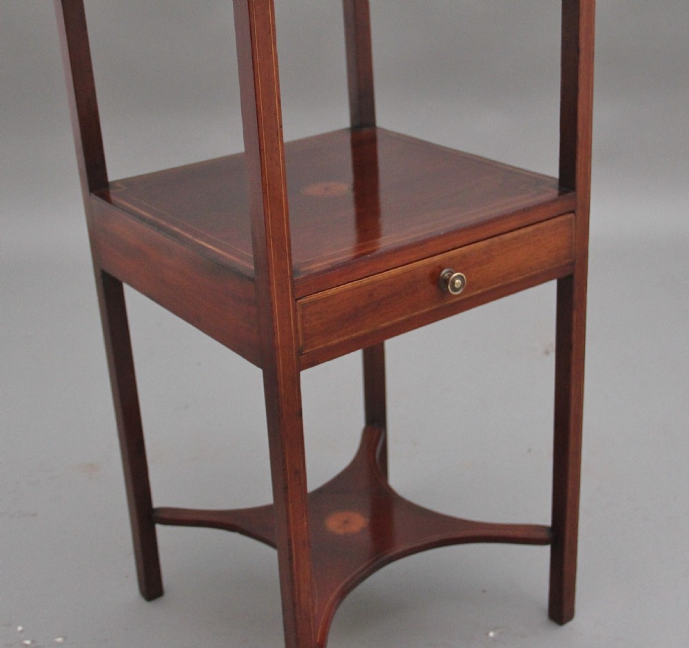 A tall, slender 19th-century mahogany bedside table featuring line inlay, a single drawer with a round brass knob, an open upper shelf tier, and an X-frame lower stretcher. View IX