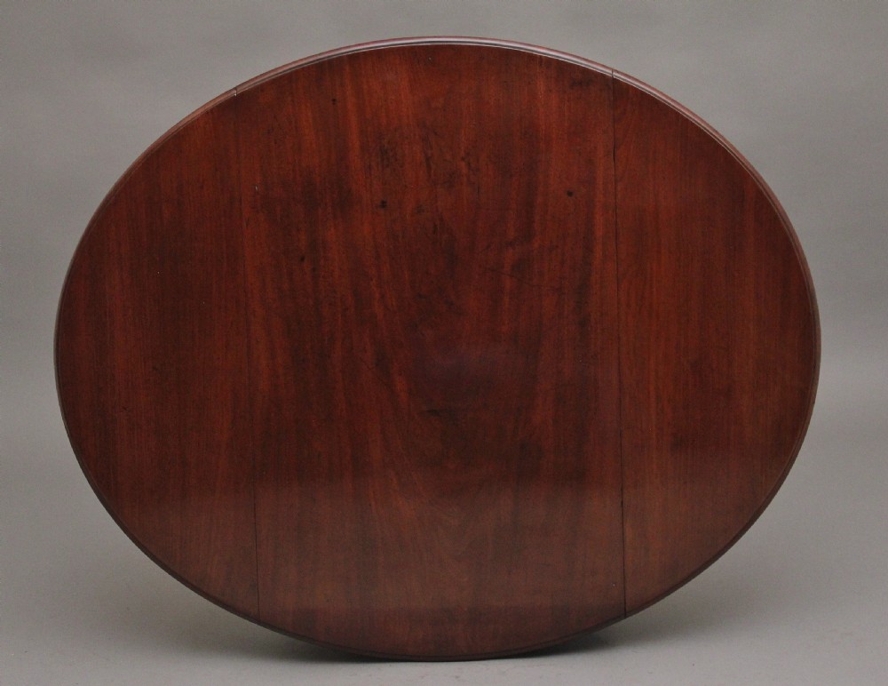 An 18th-century mahogany Pembroke table featuring drop-down curved side leaves, a front drawer with ring pull handles, and square tapered legs on brass castors. View IX