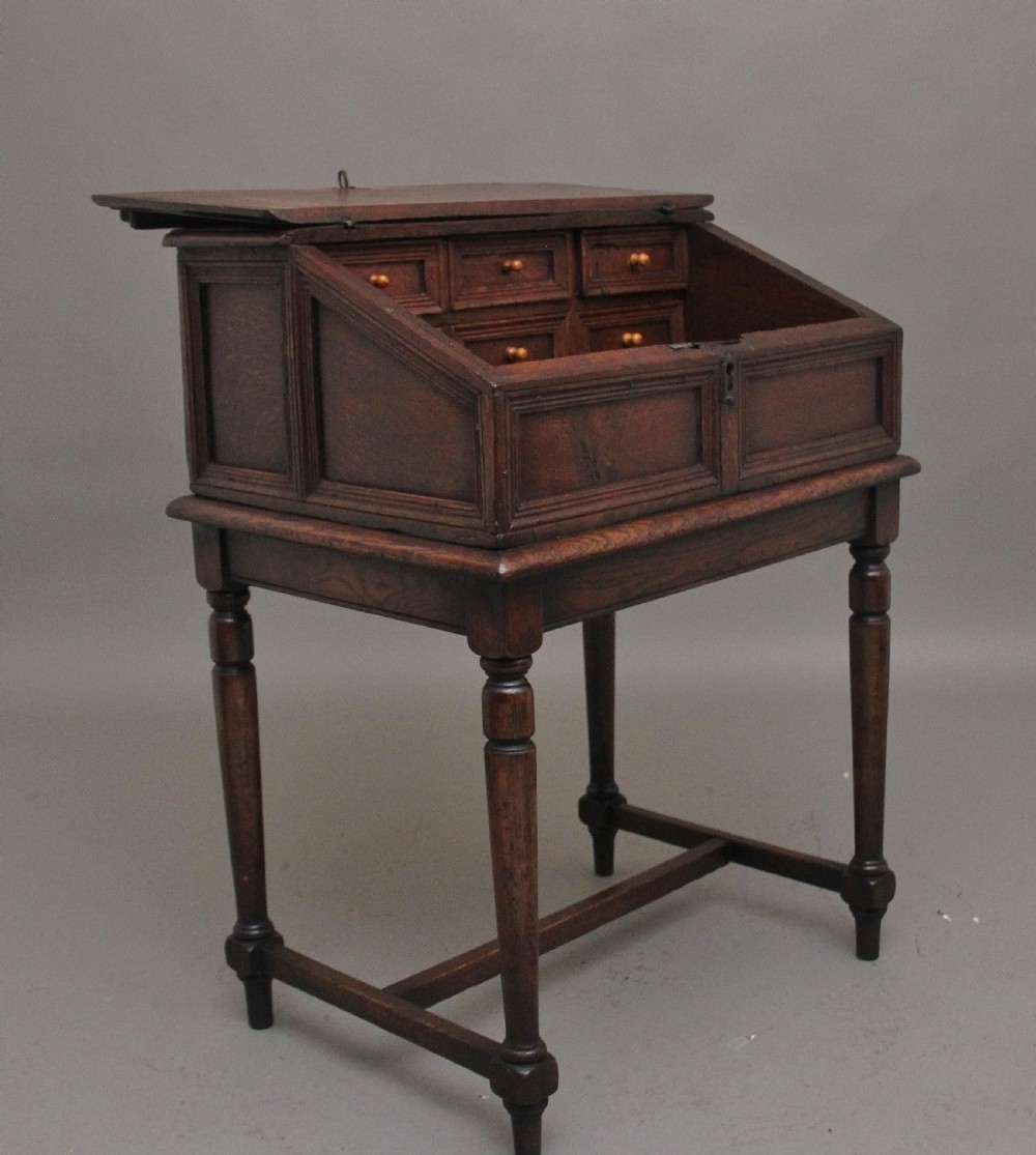 An 18th-century dark oak slope-front writing desk mounted on a stand with turned legs and lower stretchers. View II