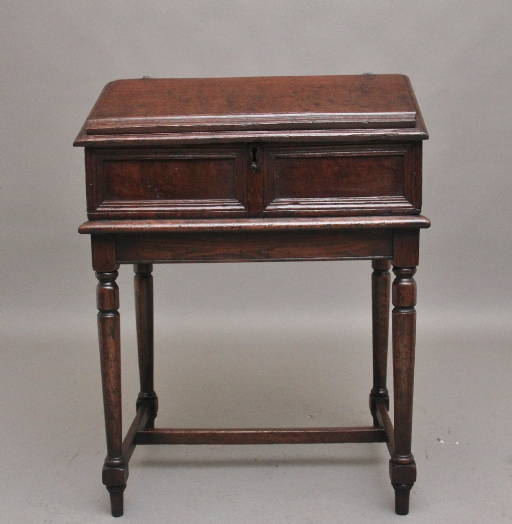 An 18th-century dark oak slope-front writing desk mounted on a stand with turned legs and lower stretchers. View III