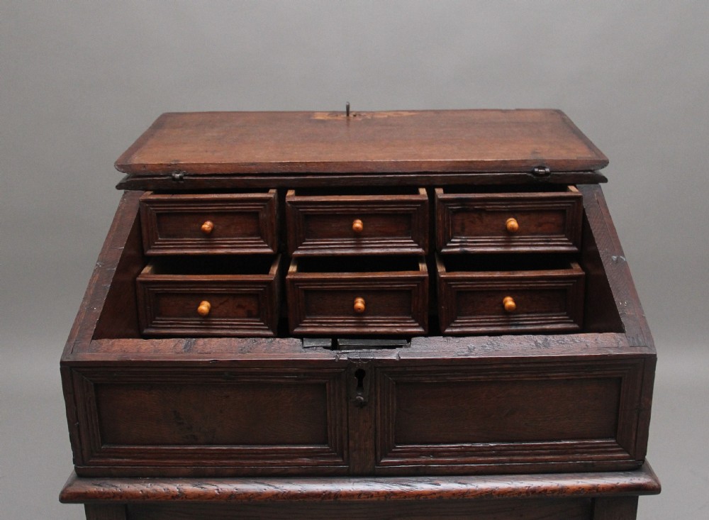 An 18th-century dark oak slope-front writing desk mounted on a stand with turned legs and lower stretchers. View VI