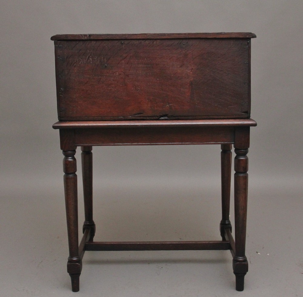 An 18th-century dark oak slope-front writing desk mounted on a stand with turned legs and lower stretchers. View VIII