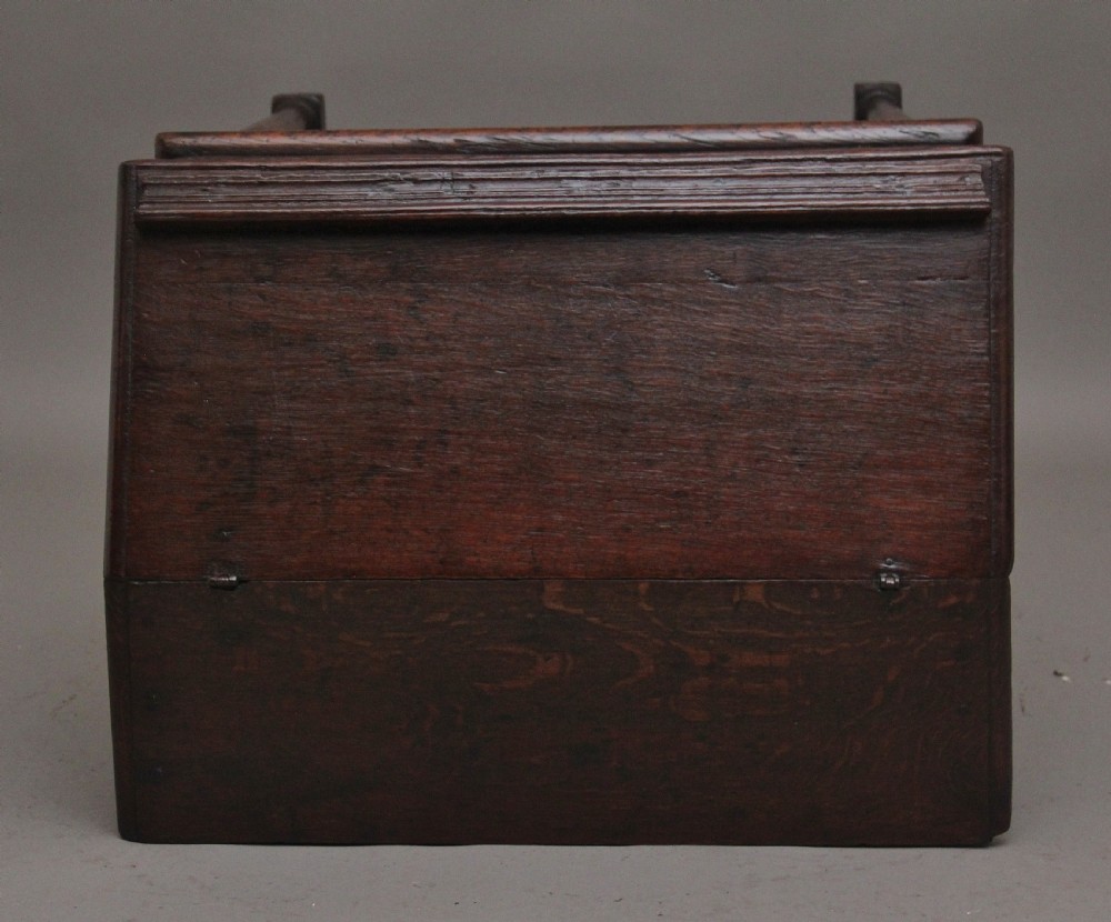 An 18th-century dark oak slope-front writing desk mounted on a stand with turned legs and lower stretchers. View X