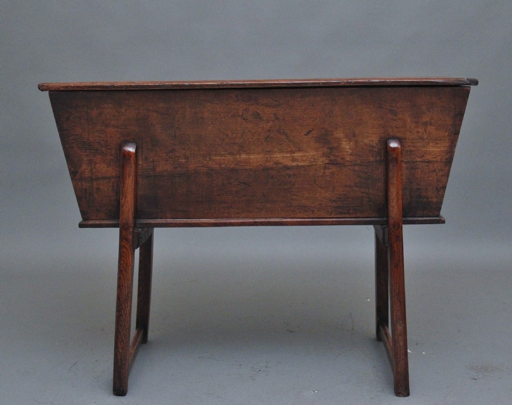 An 18th-century elm dough bin with a flat rectangular lid resting on a four-legged timber stand. View III