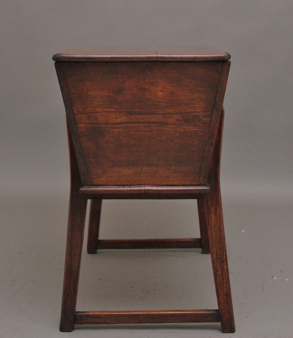 An 18th-century elm dough bin with a flat rectangular lid resting on a four-legged timber stand. View VI