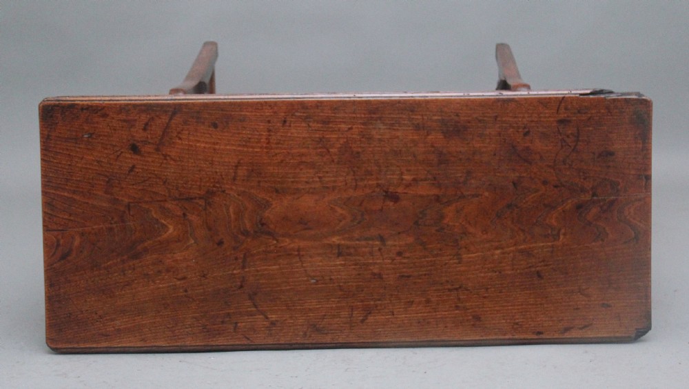 An 18th-century elm dough bin with a flat rectangular lid resting on a four-legged timber stand. View VIII